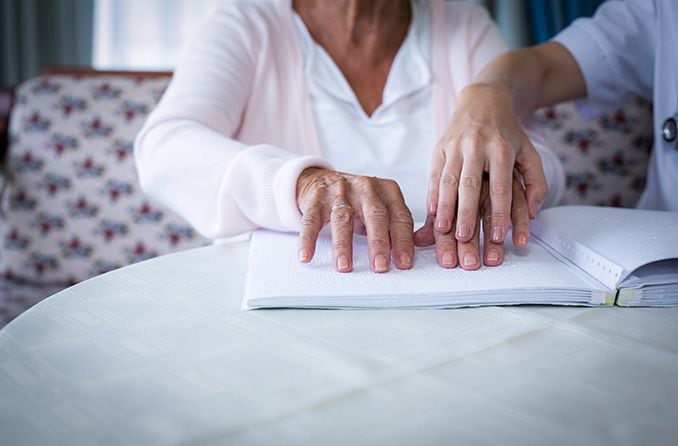 older person reading braille older person reading braille
