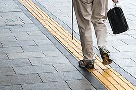 blind person walking along tactile paving blind person walking along tactile paving