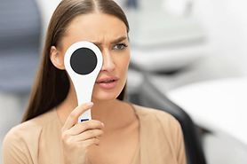 woman with blurry vision in one eye covering the other eye