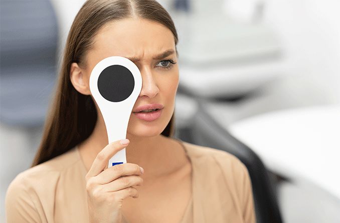 woman with blurry vision in one eye covering the other eye woman with blurry vision in one eye covering the other eye