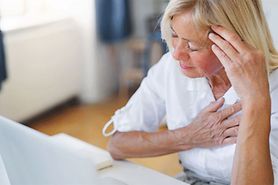 woman with eye twitching wondering if it's a sign of a stroke touching her temple and chest