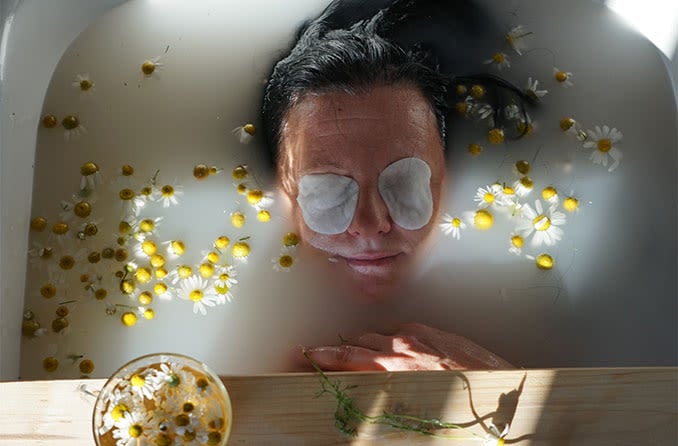 woman relaxing in a tub with compress over her eyes to naturally treat her eye floaters woman relaxing in a tub with compress over her eyes to naturally treat her eye floaters