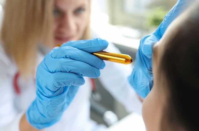 eye doctor shining a light into patient's eye to test for Argyll Robertson pupil eye doctor shining a light into patient's eye to test for Argyll Robertson pupil
