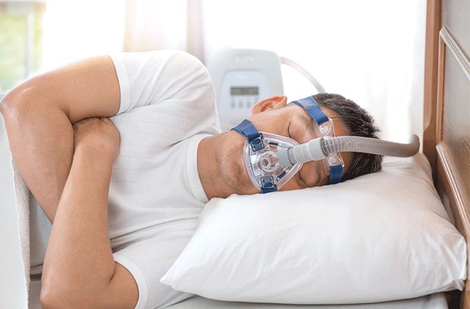 man in bed with sleep apnea wearing breathing mask man in bed with sleep apnea wearing breathing mask