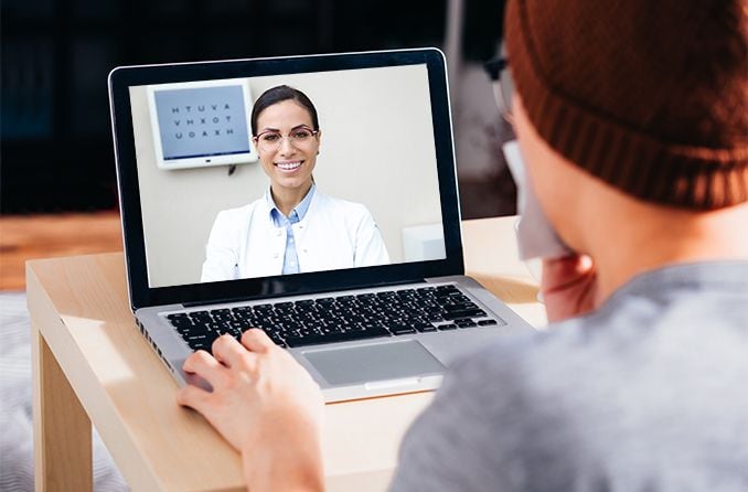 man talking with eye doctor on his laptop computer - telehealth man talking with eye doctor on his laptop computer - telehealth