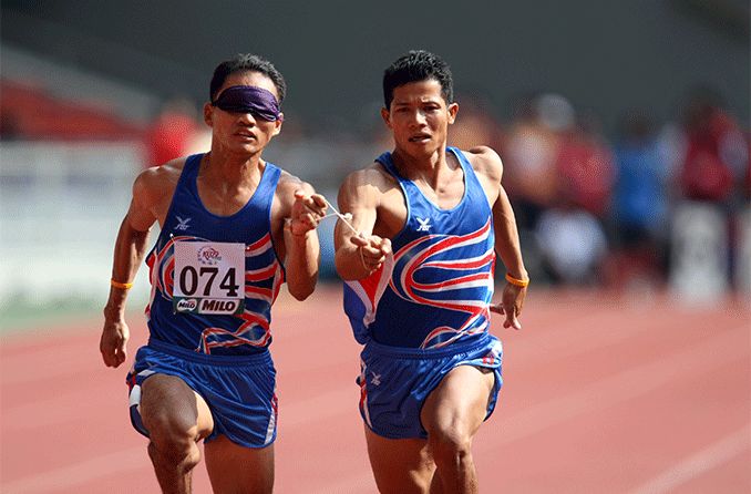 Thailand's blind athlete Kitsana Jorchuy runs with a guide at the track and field event Thailand's blind athlete Kitsana Jorchuy runs with a guide at the track and field event