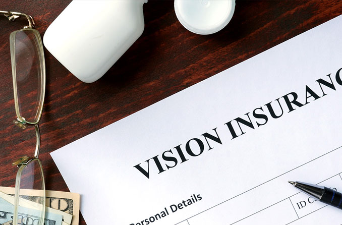 vision insurance form on desk next to reading glasses and cash vision insurance form on desk next to reading glasses and cash