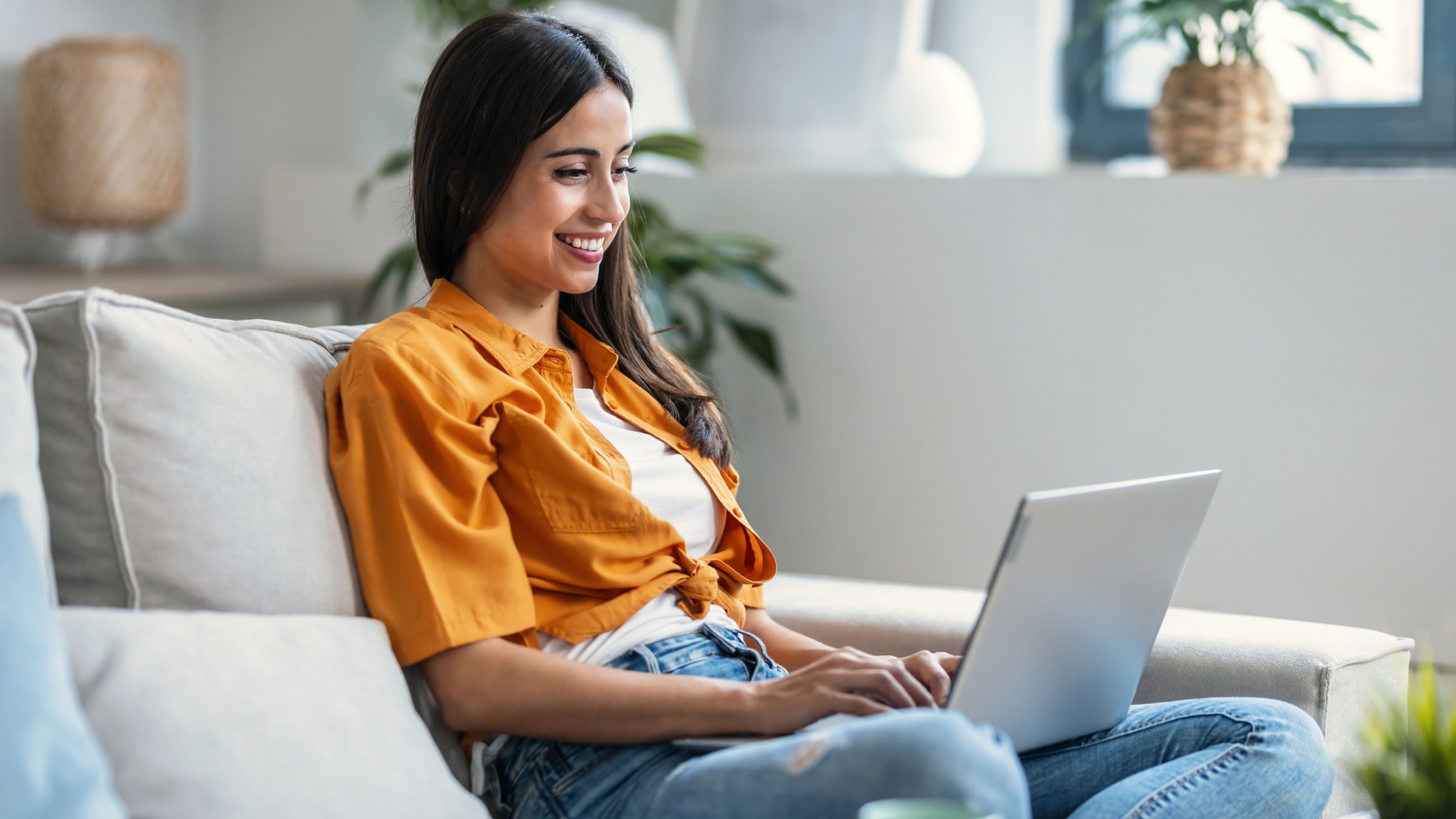 girl on couch using laptop computer