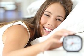 happy girl sleeping with alarm clock