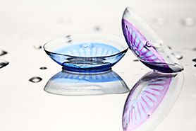 Two colored contact lenses, one for blue eyes and one for purple eyes.