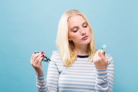 woman looking perplexed trying to decide between contacts or glasses