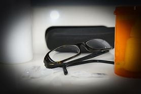 Person with glaucoma looking at a pair of glasses