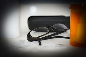 Person with glaucoma looking at a pair of glasses