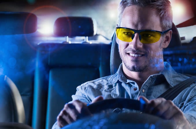 Man wearing night driving glasses while driving Man wearing night driving glasses while driving