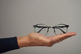 hand holding a pair of eyeglasses ready to donate