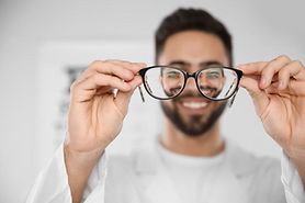 eye doctor holding up a pair of eyeglasses