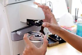 Person working with eyeglass machine.