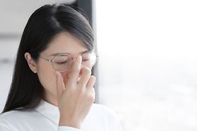 Asian woman pushes up her glasses.