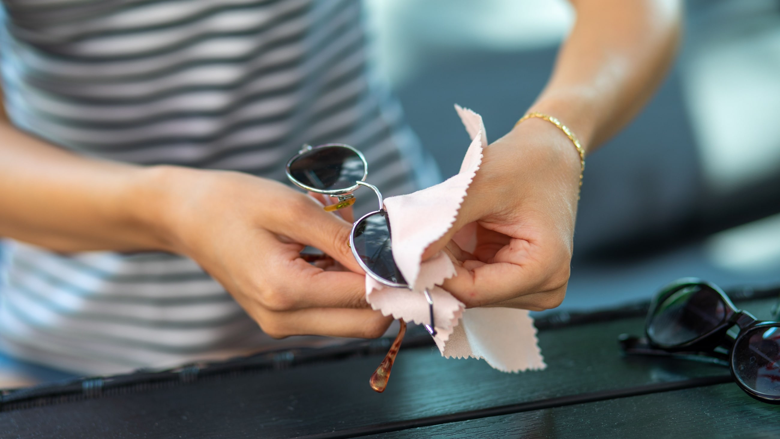 miniature men taking care of pair of sunglasses