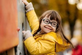 down syndrome child wearing glasses playing