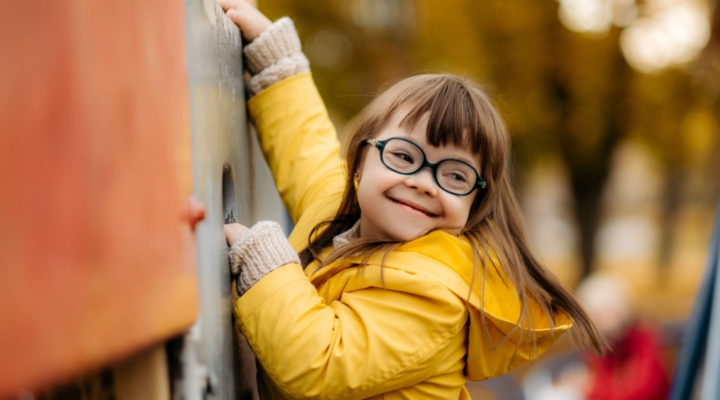 down syndrome child wearing glasses playing